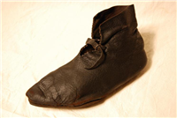 A rare complete leather medieval shoe, worn by a woman.